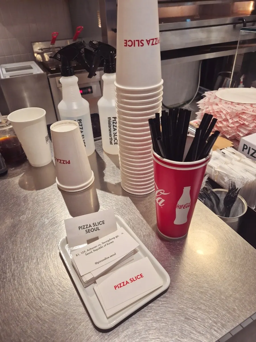 Slice pizza menu board posted at the counter