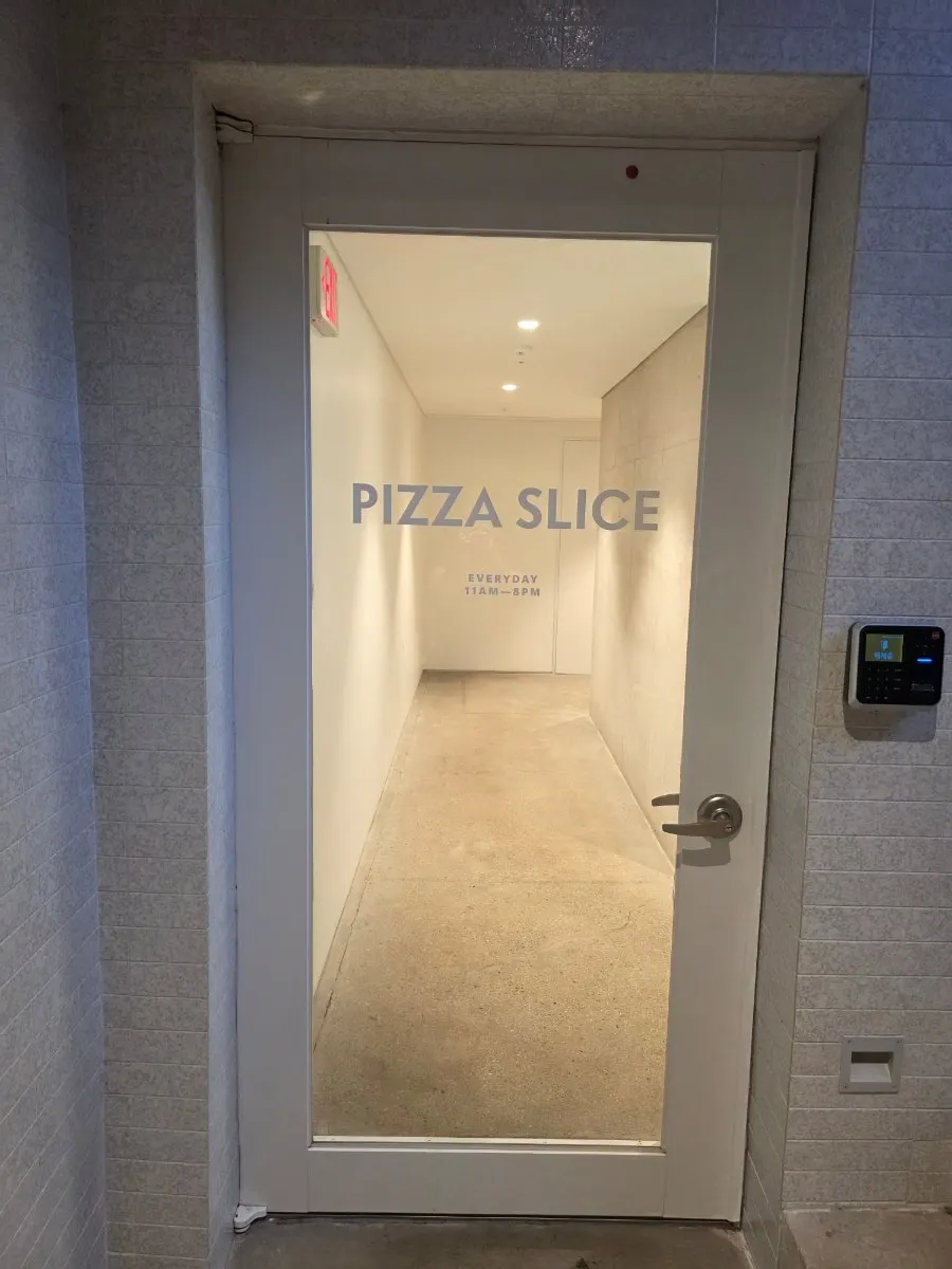 White-toned basement-level entrance of Pizza Slice Seoul