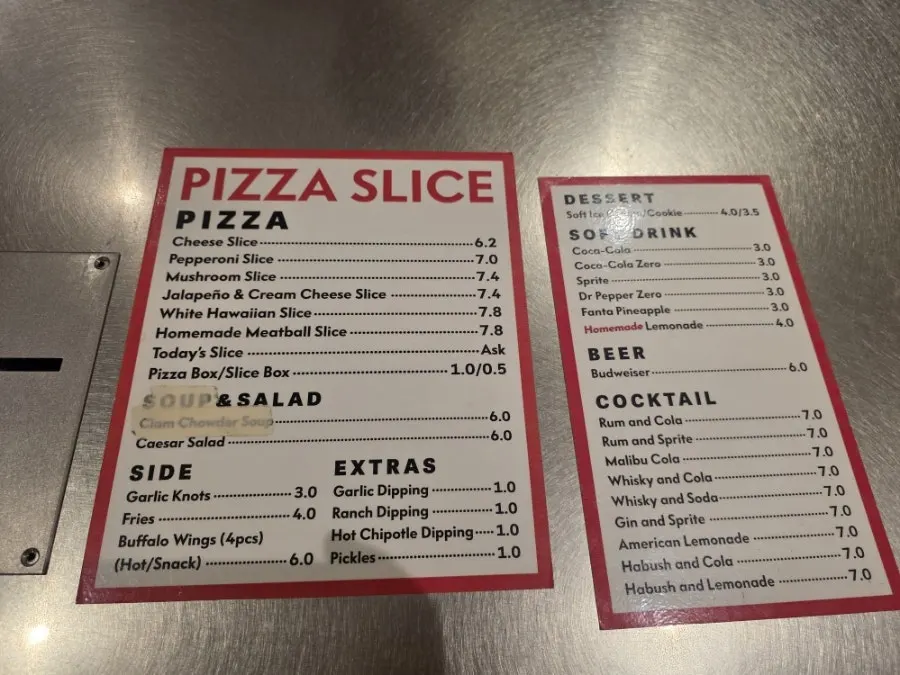 Large slices of pizza displayed in the case