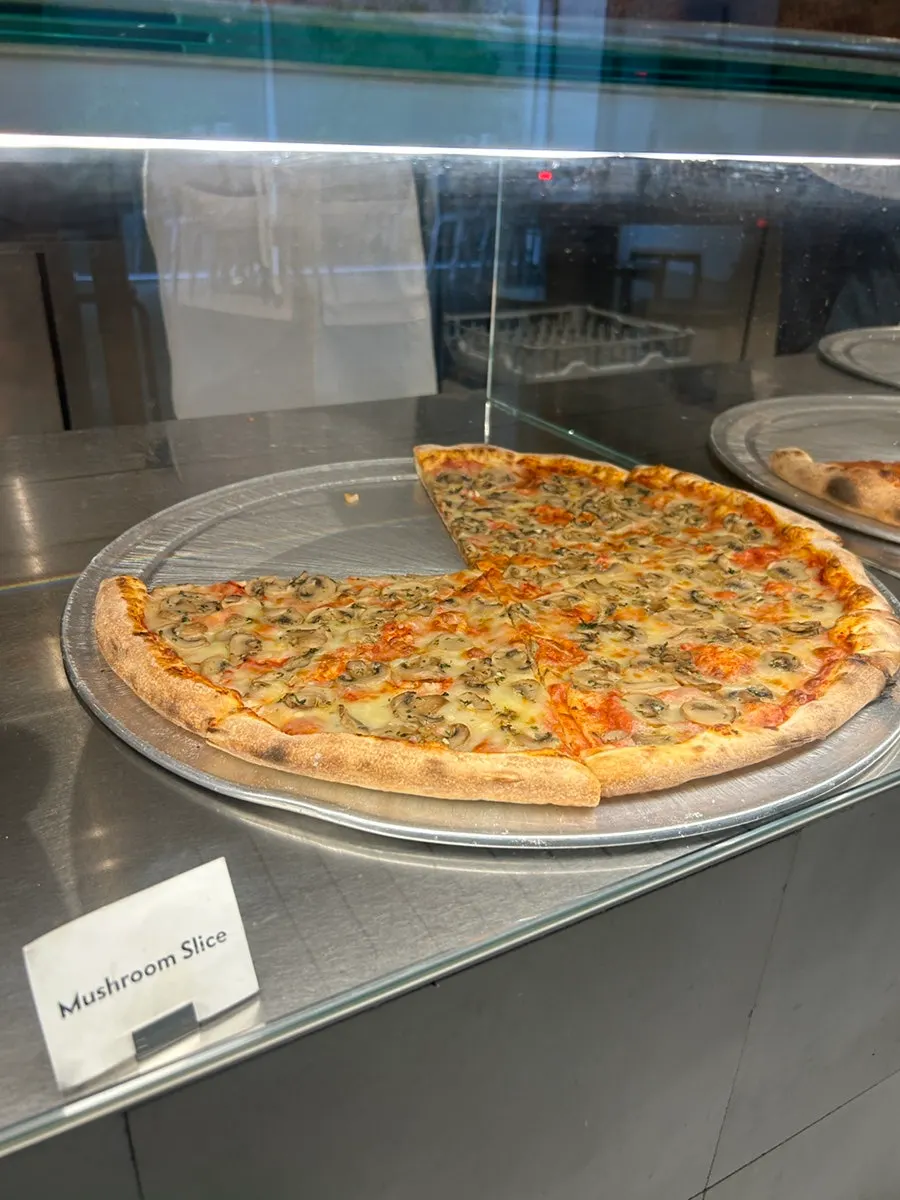 A pizza slice large enough to cover a face