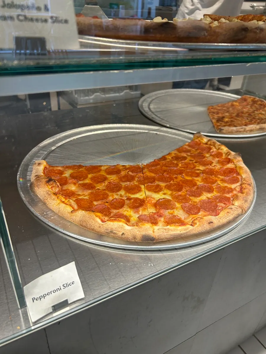 A pizza slice showing its crispy edge