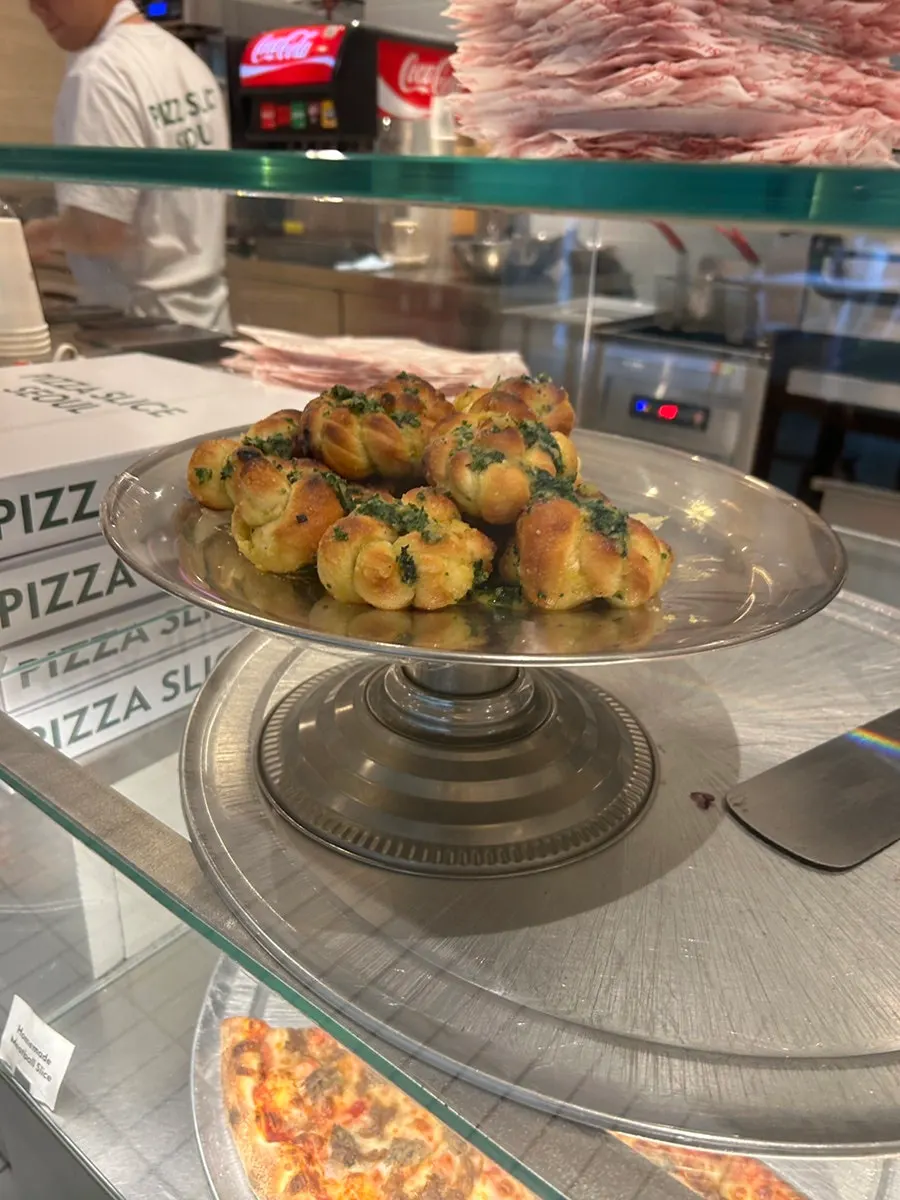 A pizza slice sprinkled with seasoning