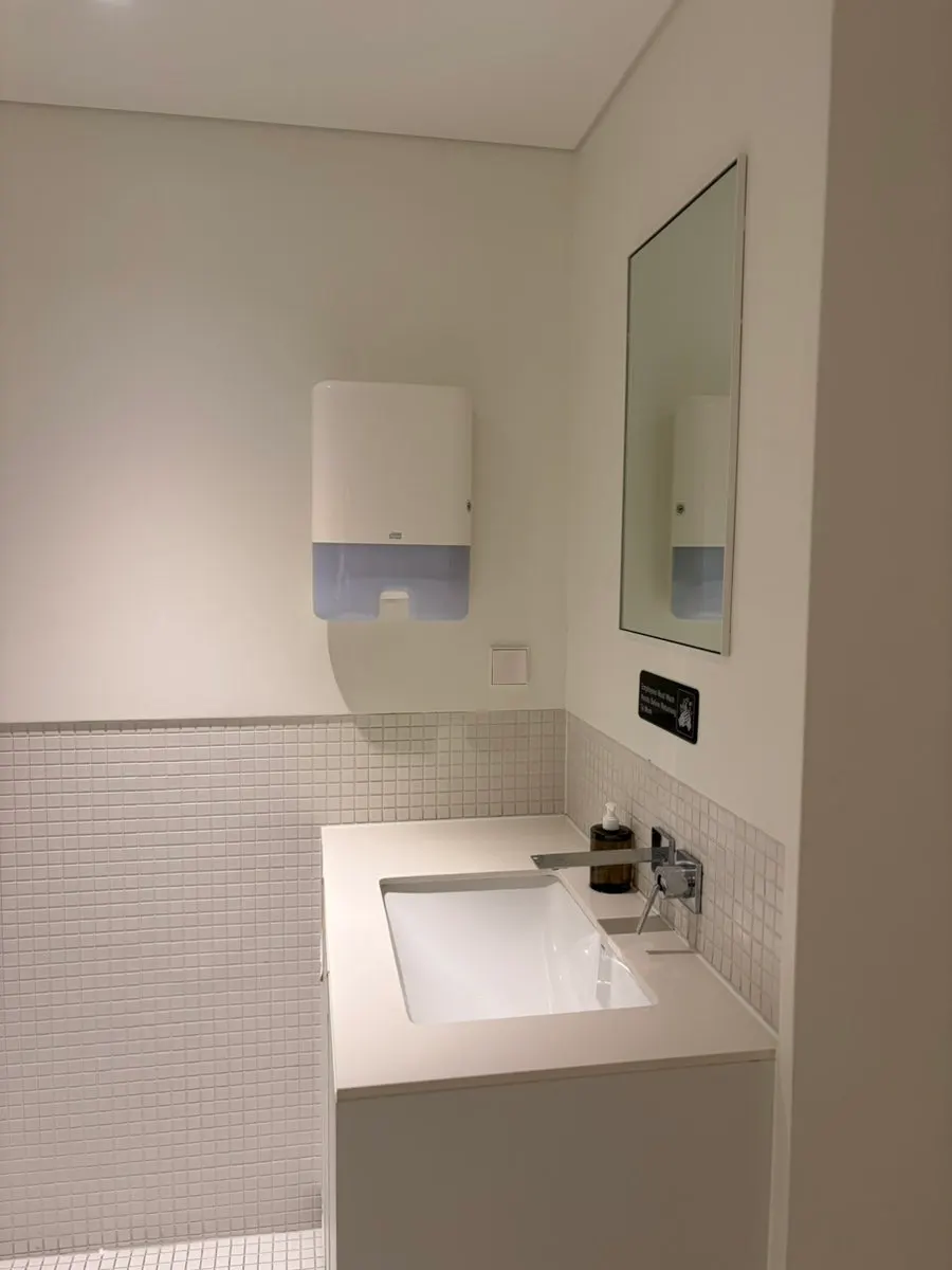 Restroom with sink, mirror, and hand towel dispenser