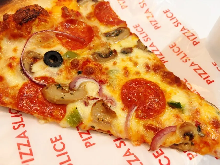 Pizza cut with a disposable fork and plastic knife