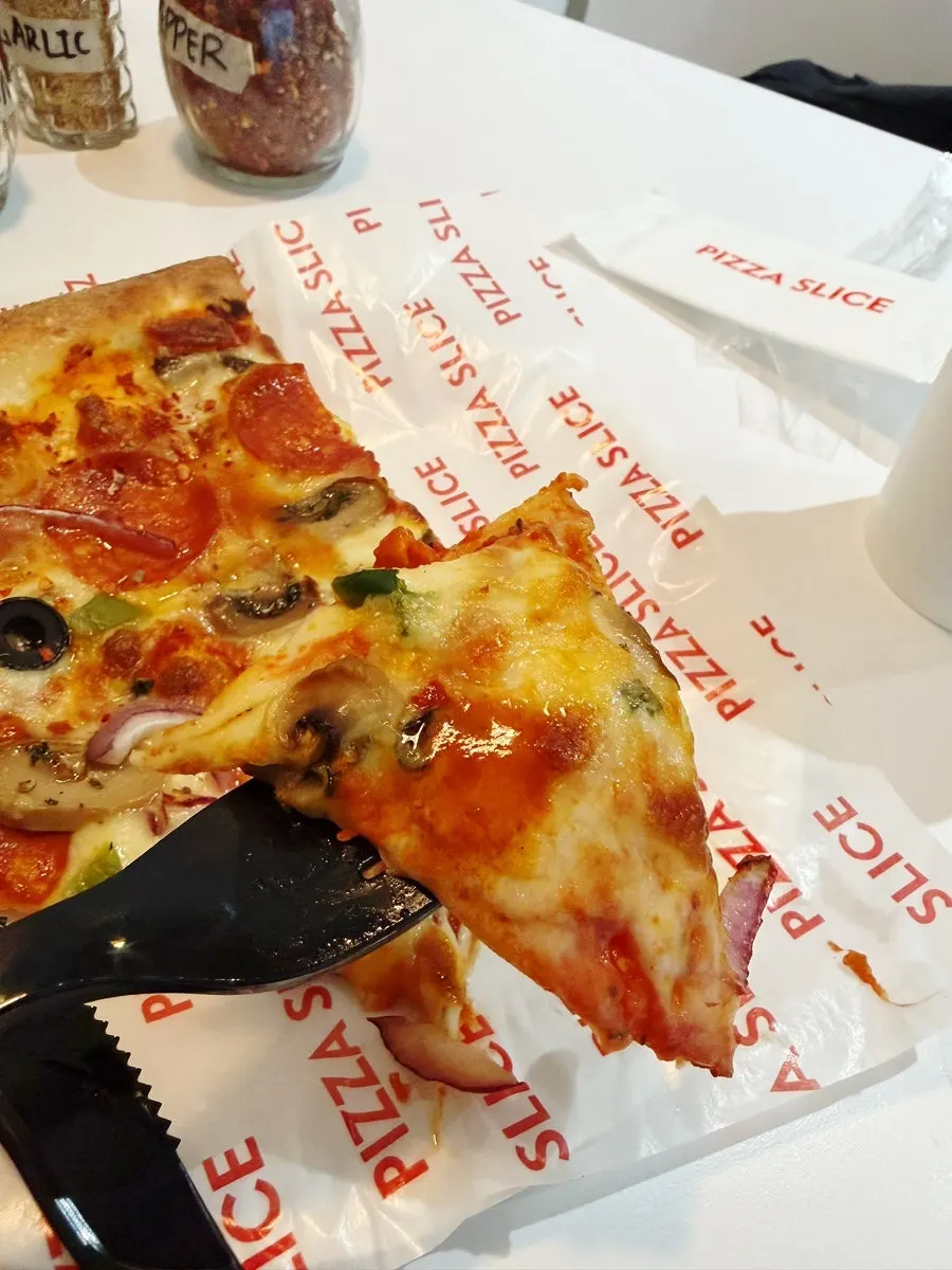 Cross-section of a thin-crust pizza showing cheese and toppings