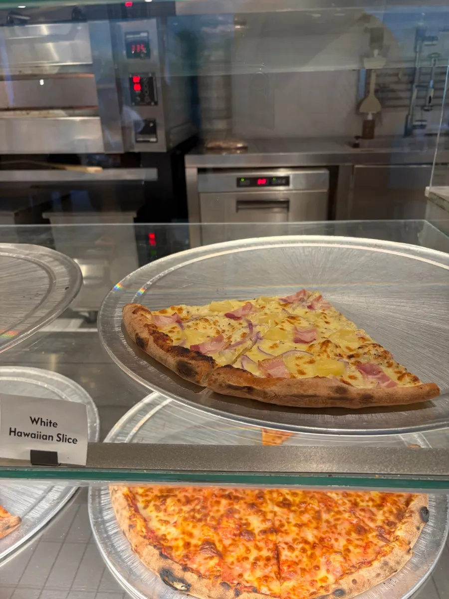 Menu board listing pizza slices, beer and cocktails