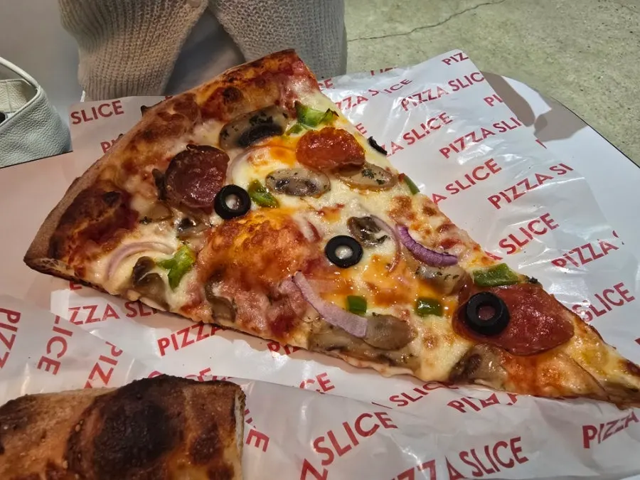 A slice of Hawaiian cheese pizza