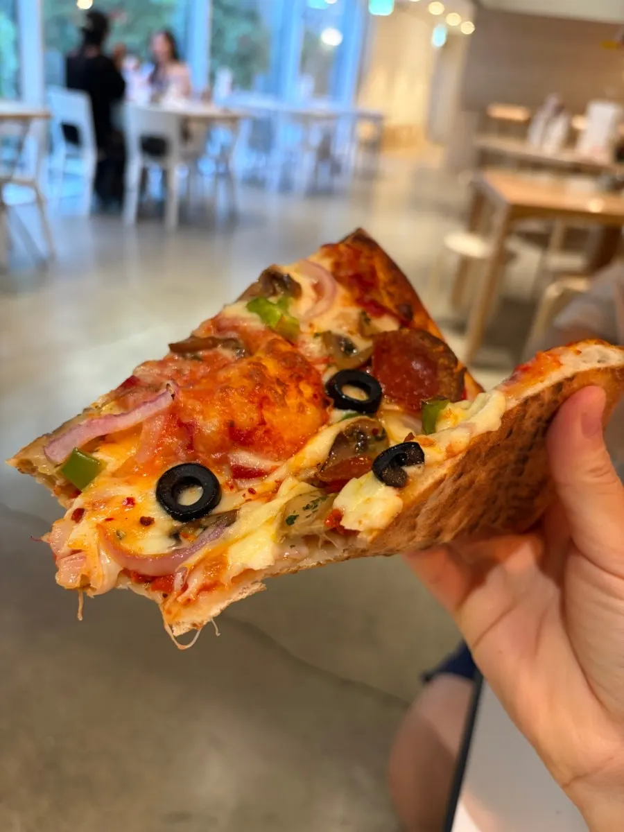 A topping-loaded combination pizza slice of the day