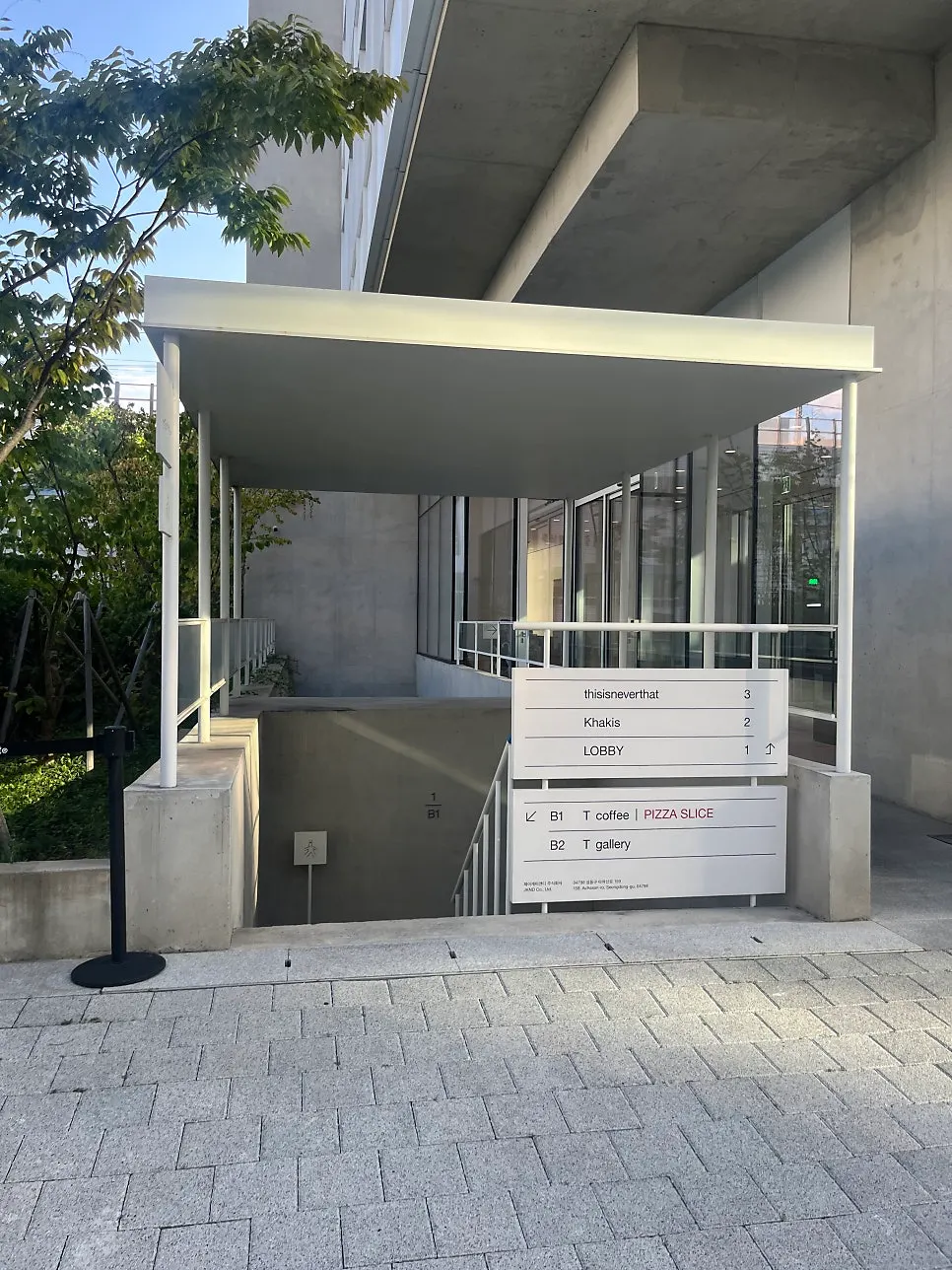T Coffee building entrance with exposed concrete finish and signage
