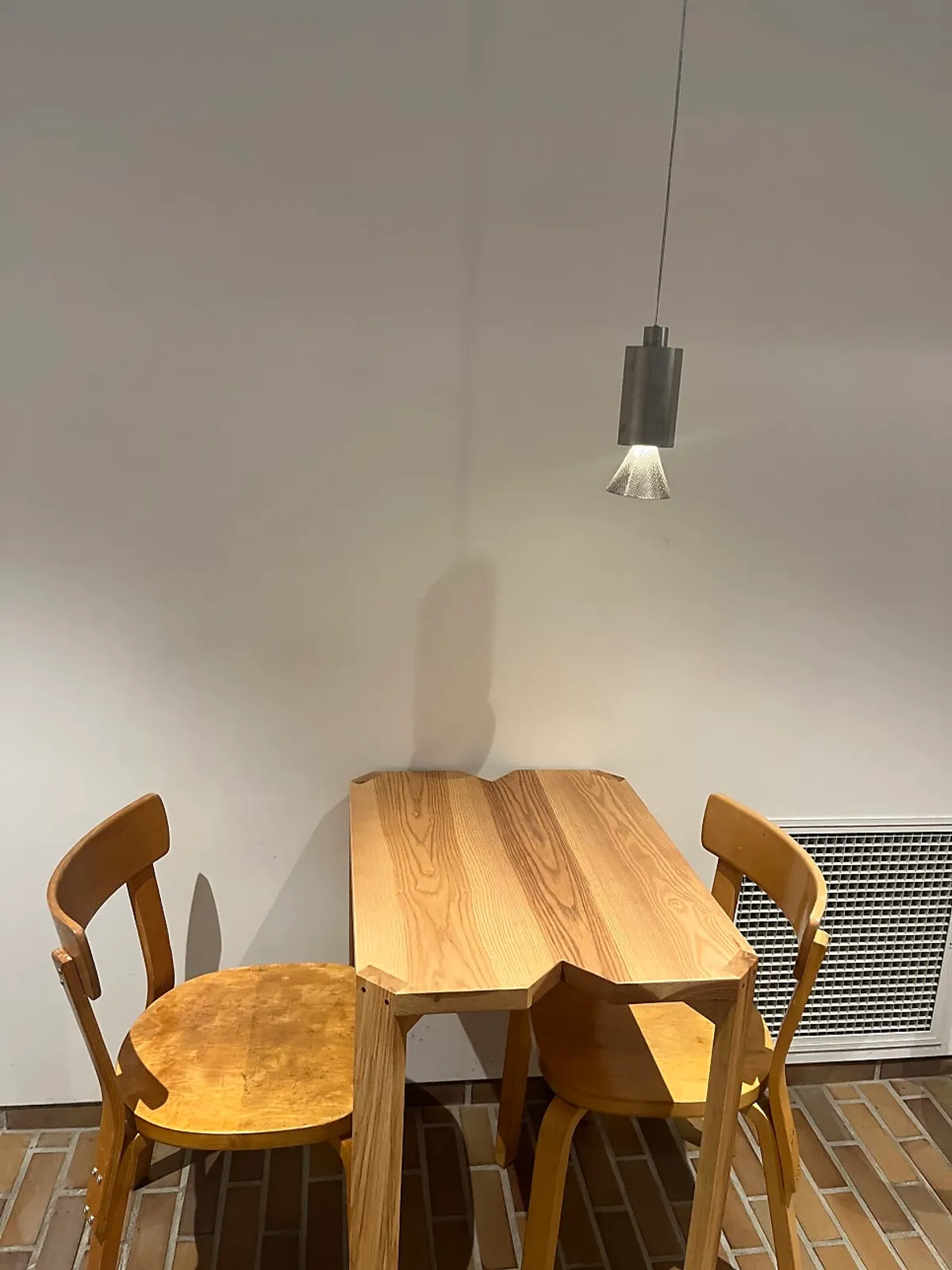 Corner two-person table under a pendant light
