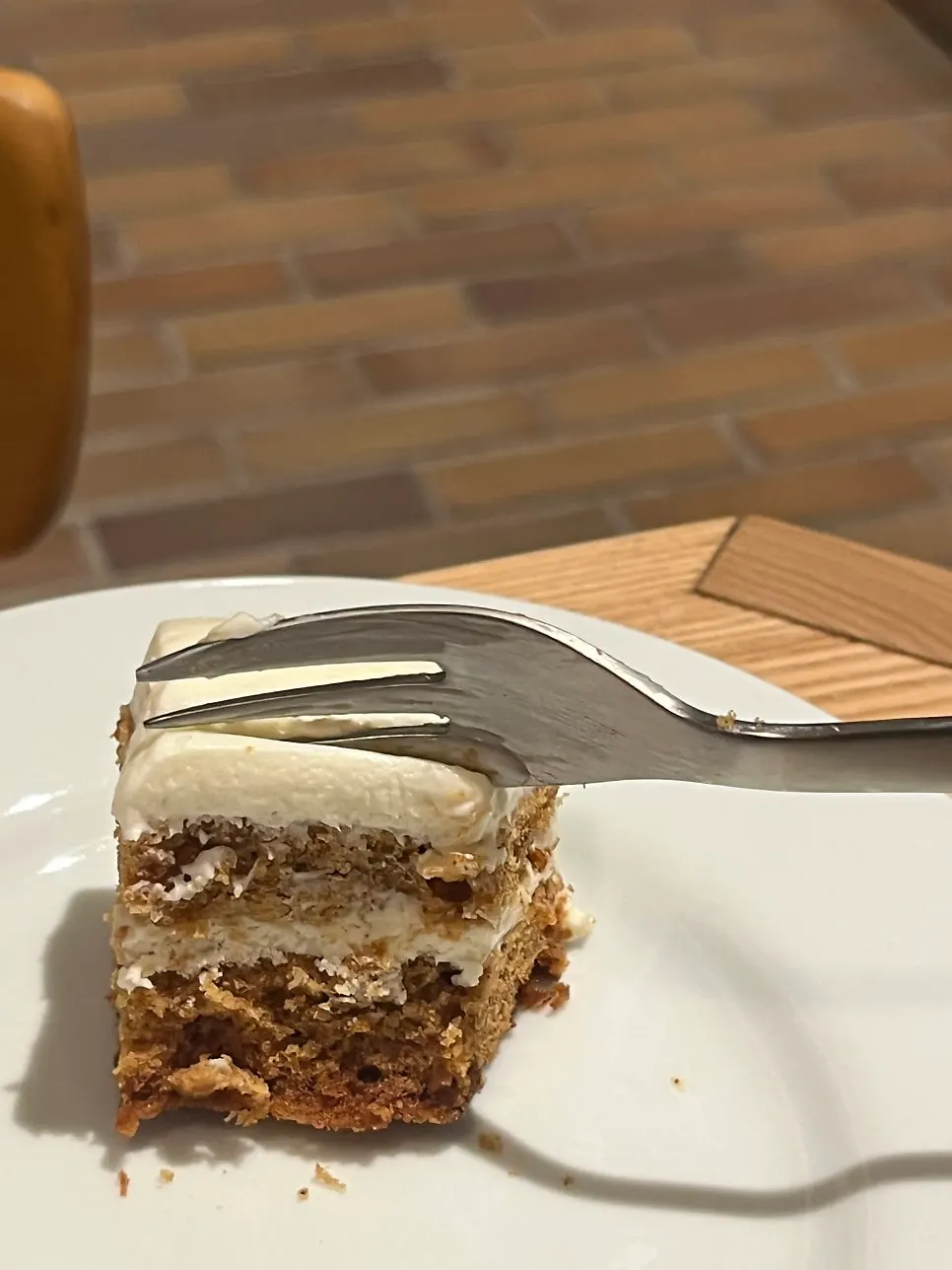 Iced coffee and a slice of carrot cake next to a laptop