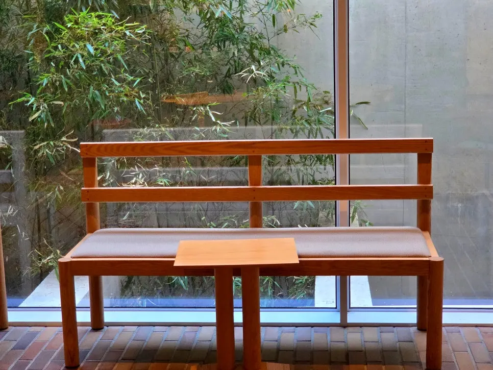 Window seat with a view of the floor-to-ceiling window and green landscaping