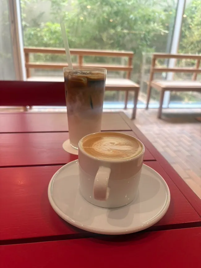 Two drinks set on a window seat table at T Coffee