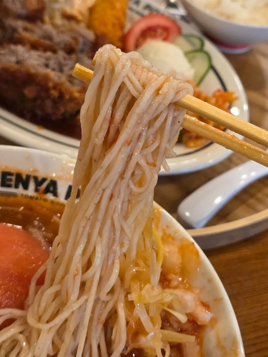 Fideos del Real Tomato Ramen levantados con los palillos