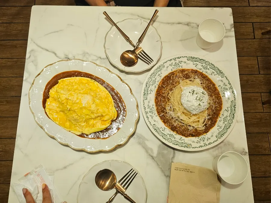 Omelet rice and pasta served on the table