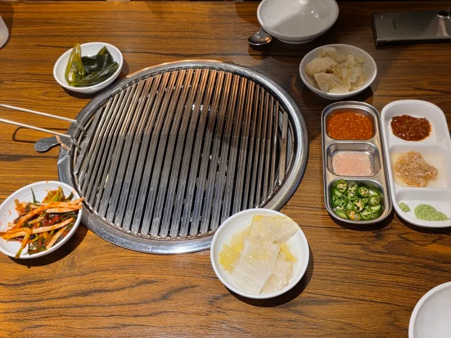 Table set with green onion kimchi, wild garlic leaves, and other basic side dishes