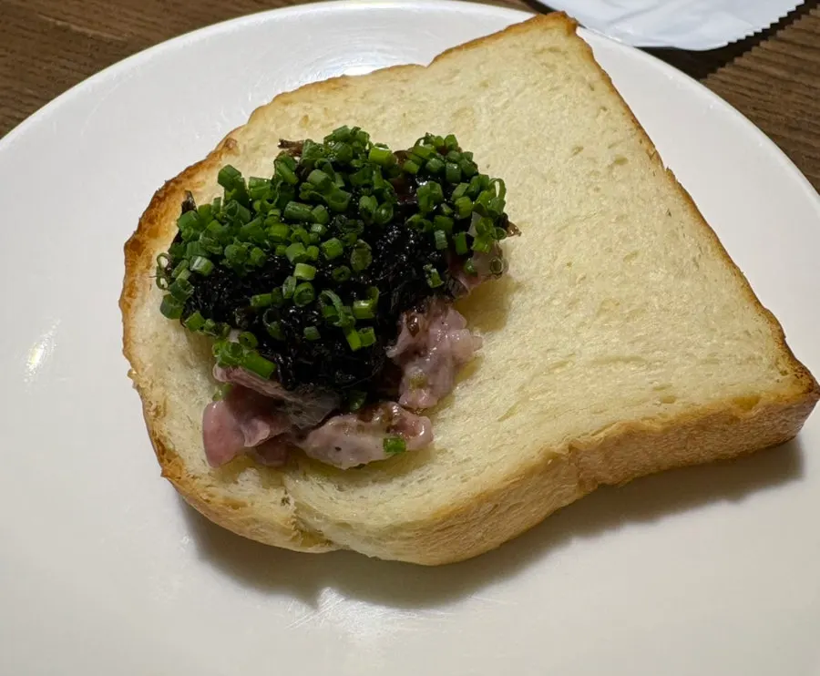 Beef tartare plated with a ring of green oil