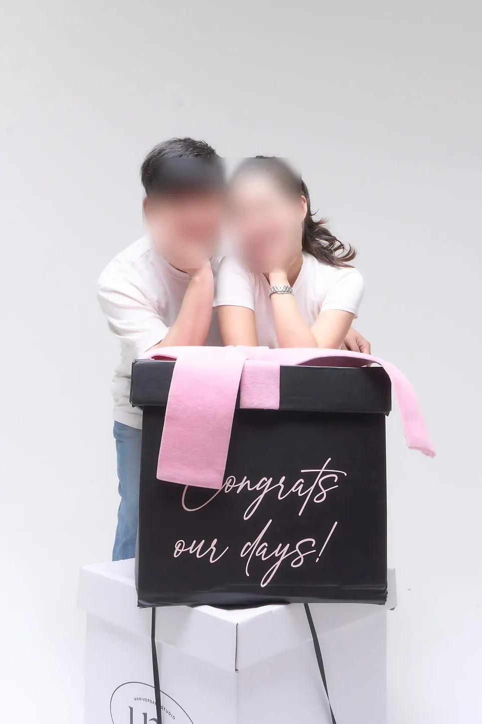 Maternity snap with chin resting on two gift boxes