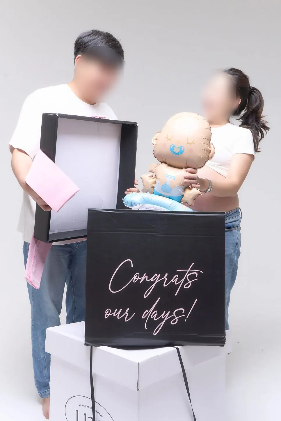 Maternity snap pose opening a gift box in surprise