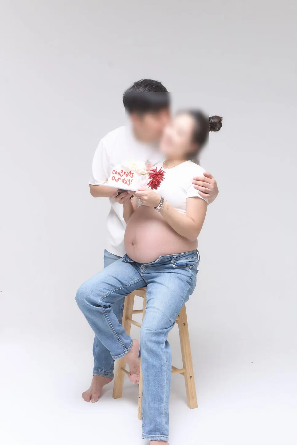 Maternity photo pose with baby uniform and red cheer stick