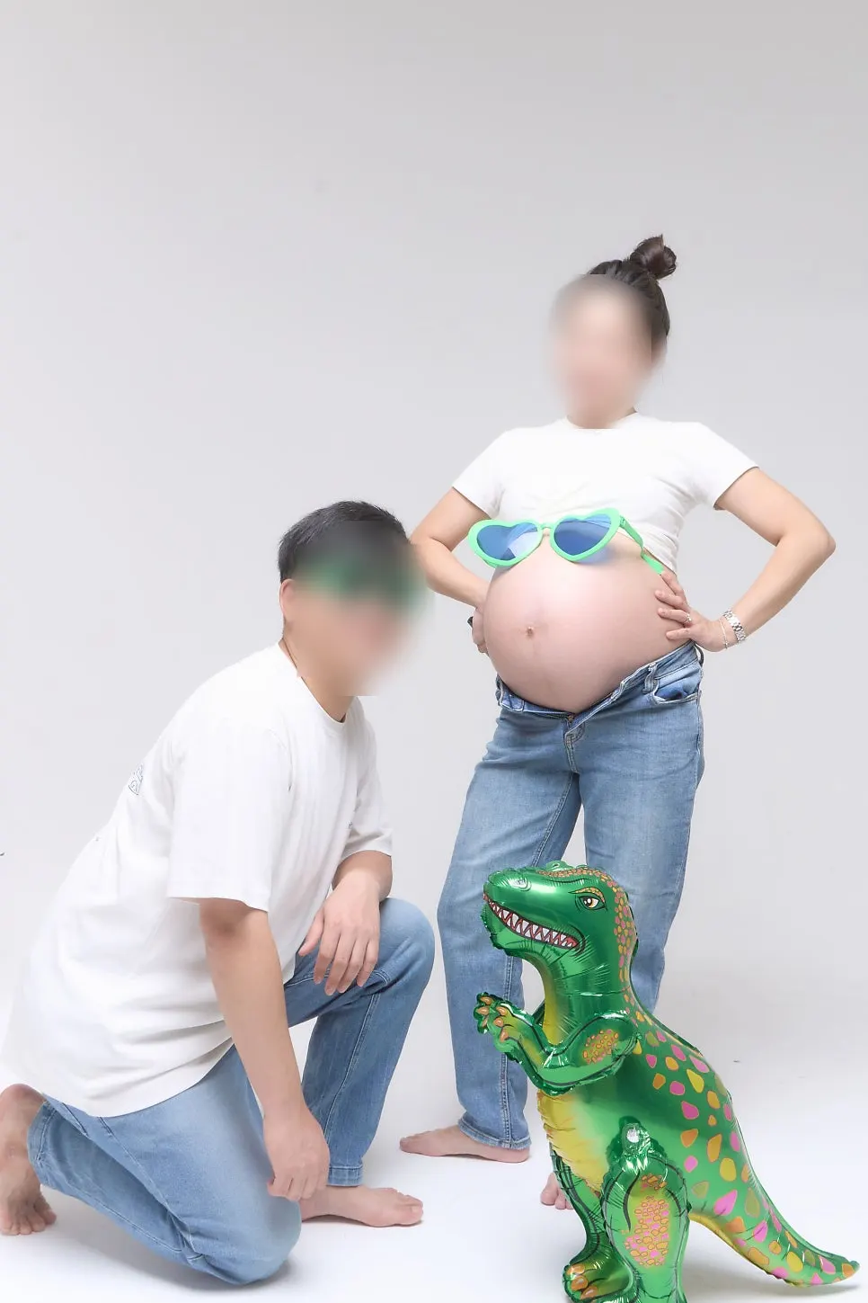 Couple's maternity snap holding a model cake