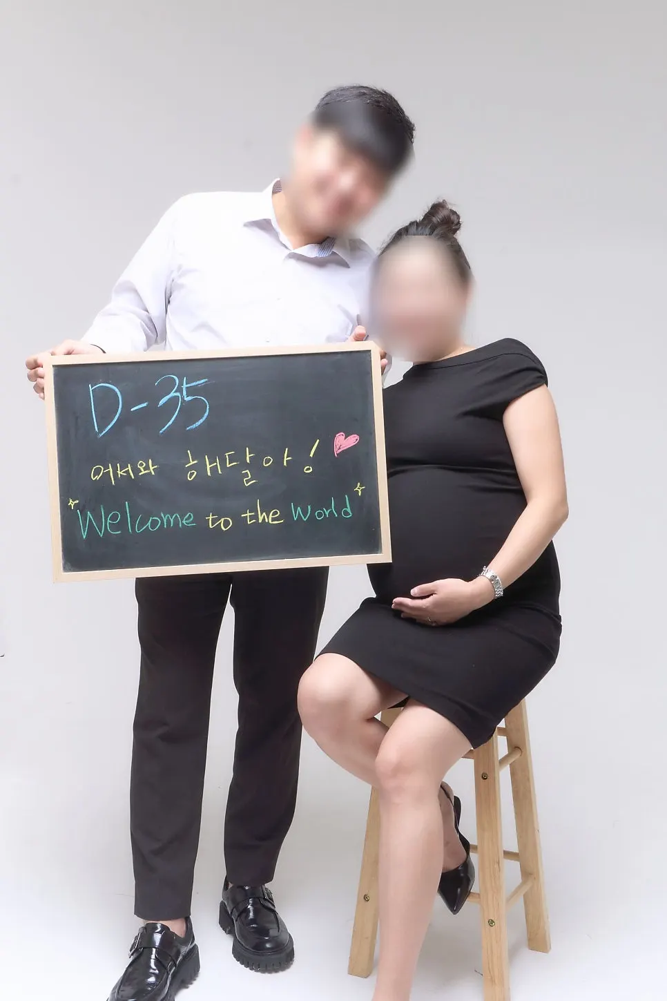 Final maternity shoot photo holding a chalkboard