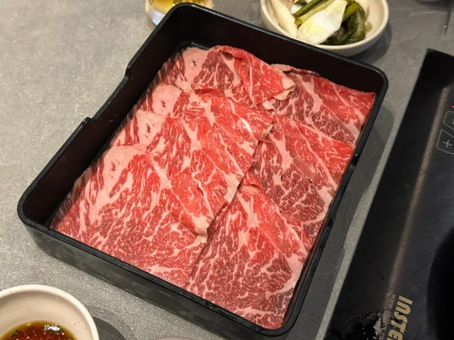 Thin shabu meat being cooked in the broth