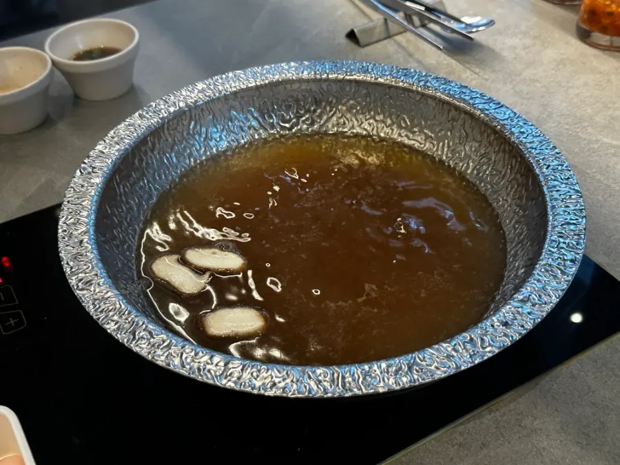 A glass of beer alongside the shabu-shabu