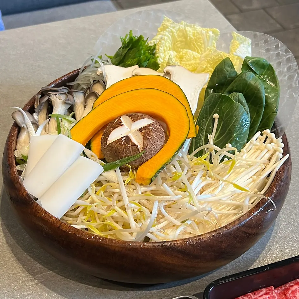 A plate of assorted mushrooms, vegetables, and glass noodle cakes