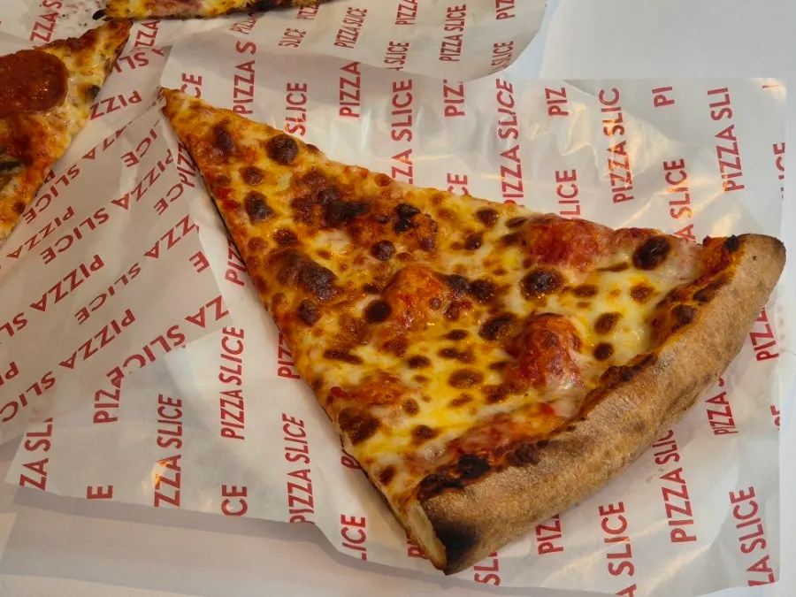 A slice pizza showing its crispy crust edge