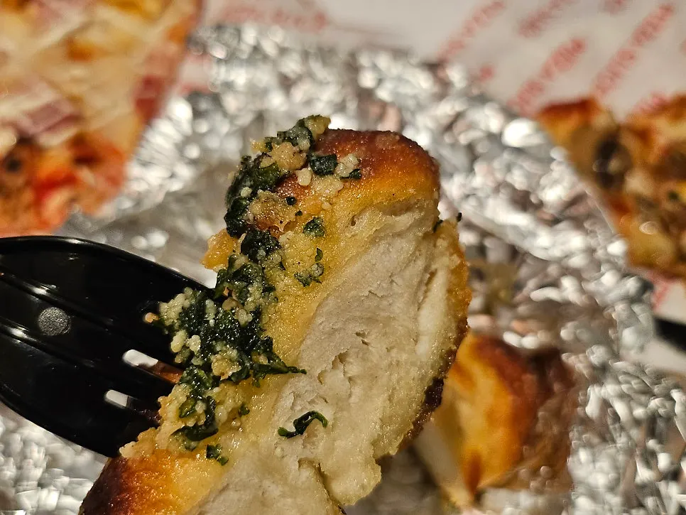 Pizza slices served alongside the garlic bread