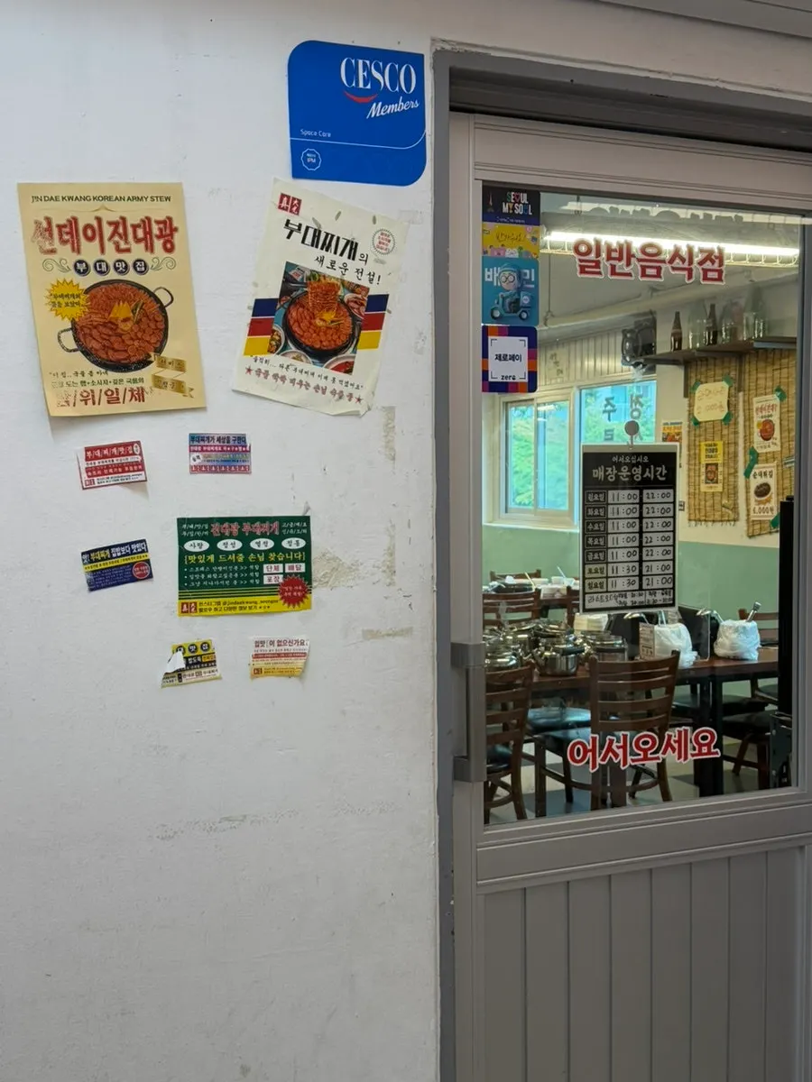 Retro Jindaegwang Budae Jjigae sign and old-style posters
