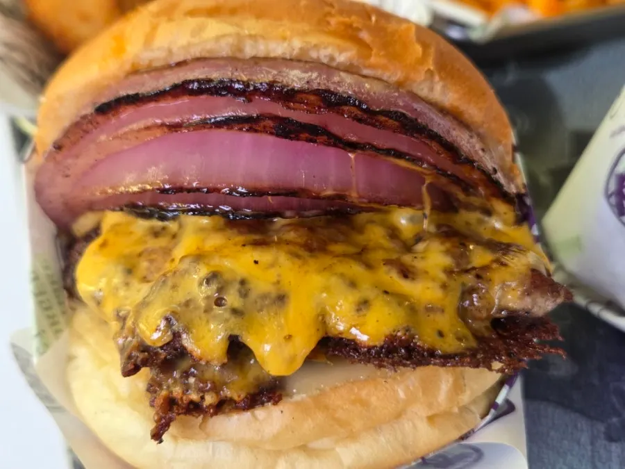 Taking a big bite of the double cheese burger