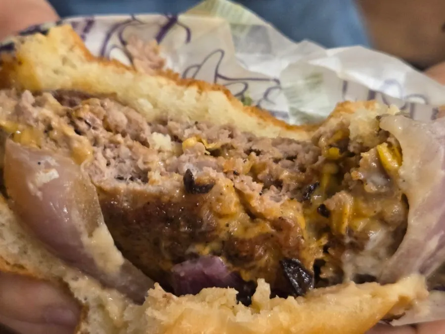 Holding the burger with both hands while eating