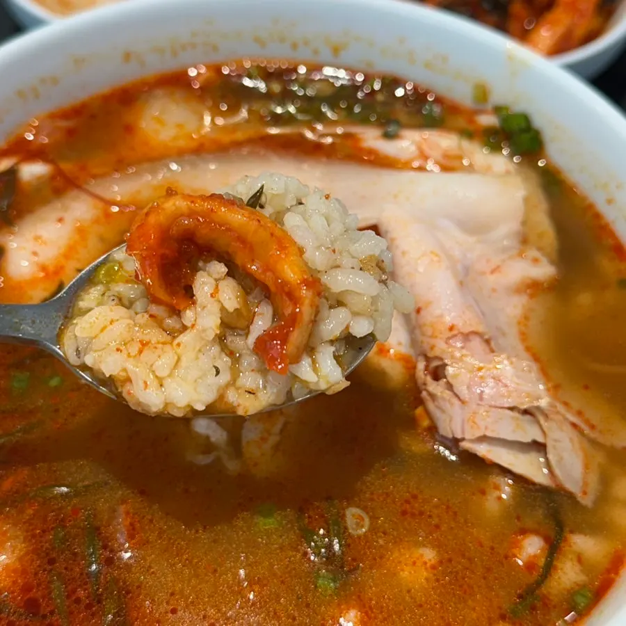 Eating the spicy gomtang together with the side dishes