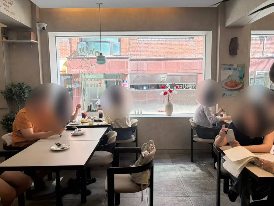 Interior seating at Omil Seongsu with sunlight through floor-to-ceiling windows