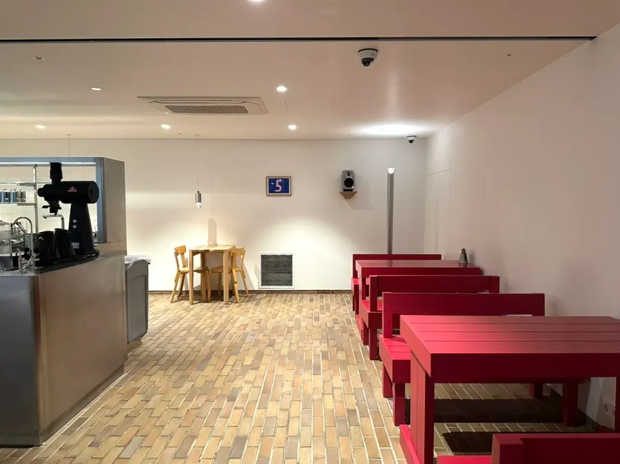 Red tables and benches in a white-toned space