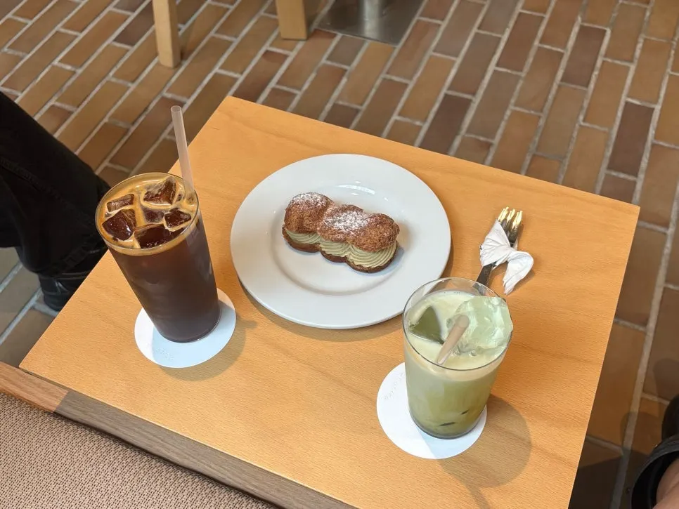 Iced americano topped with crema next to a matcha latte
