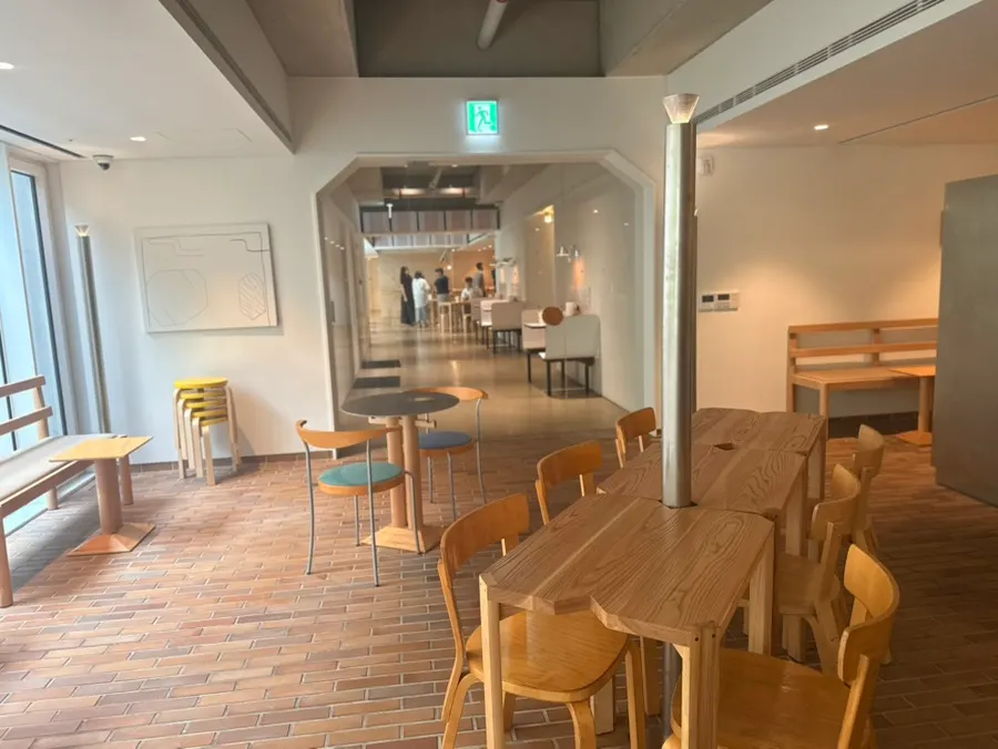 Interior of the café with floor-to-ceiling windows and varied tables