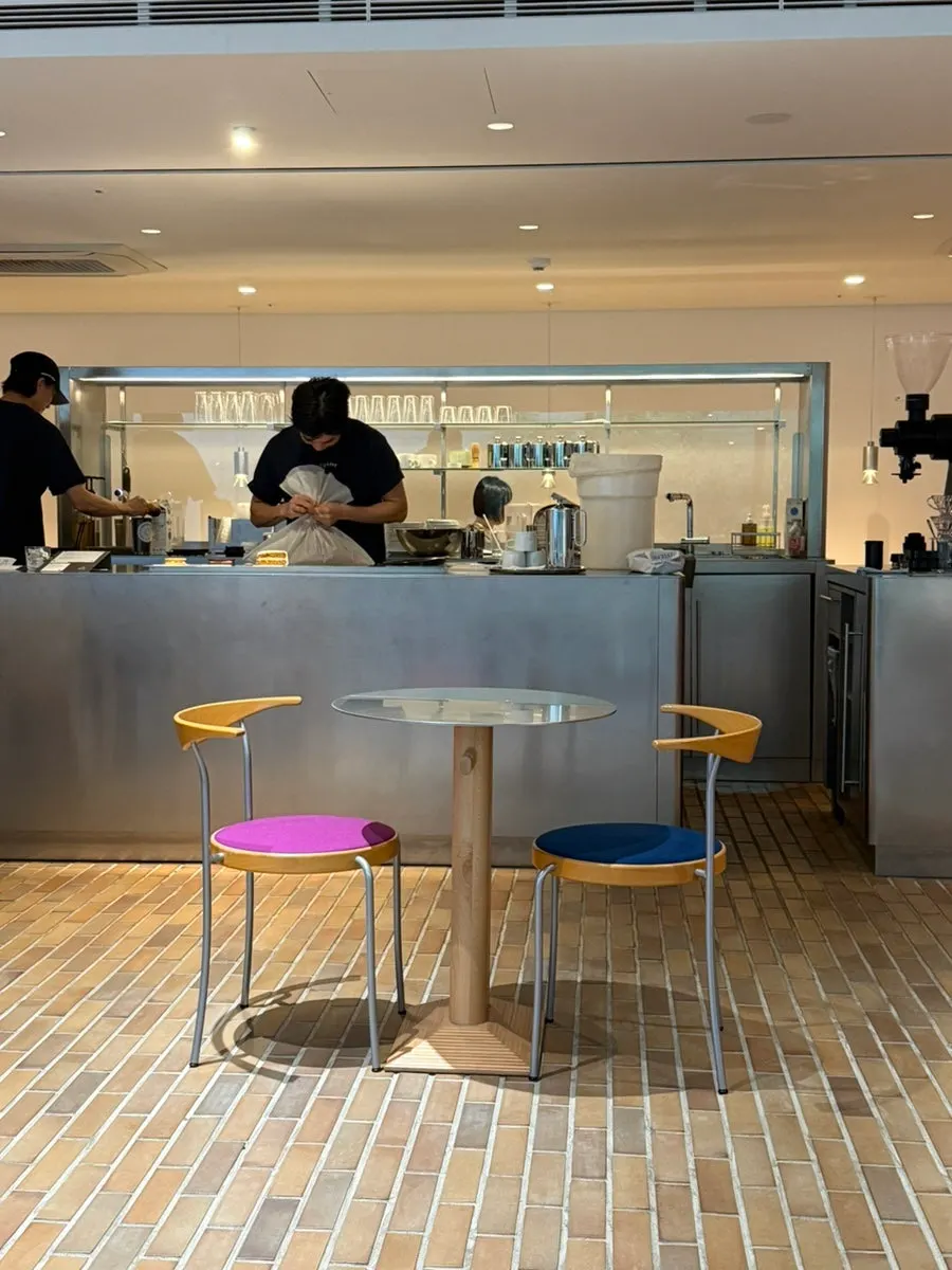 Café space with floor-to-ceiling windows and outdoor landscaping