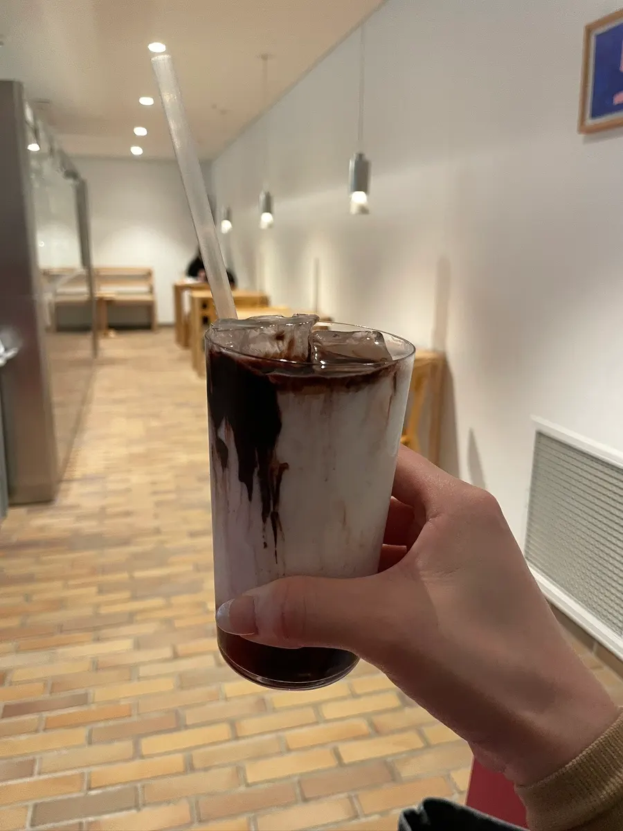 Iced chocolate latte glass with chocolate settled at the bottom