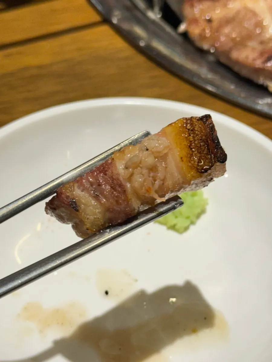 A piece of pork belly with salt and fresh wasabi