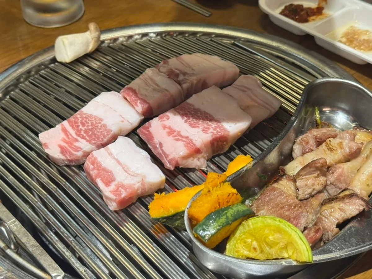 Grill full of cooked pork belly and pork neck at Seongsu Teojeon