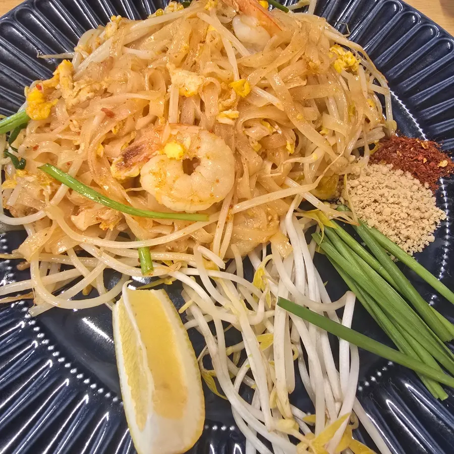 A plate of Thanon55 pad thai with bean sprouts and chives