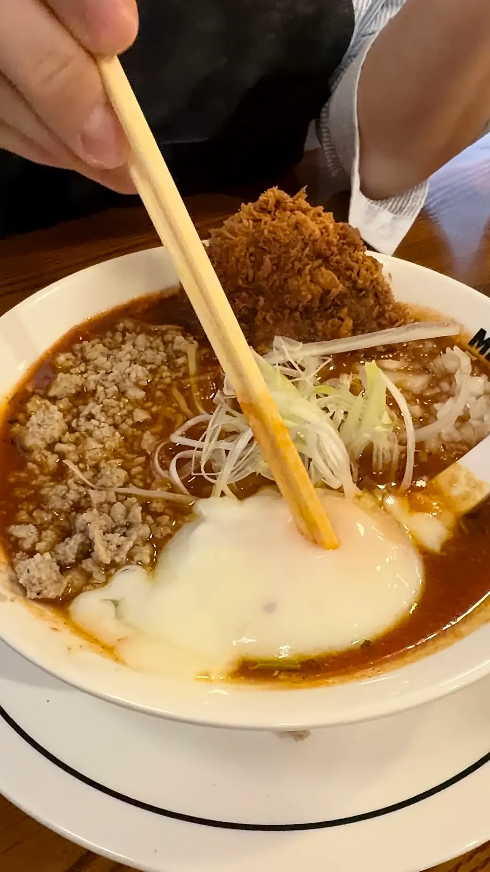 Lifting up the noodles from the tomato ramen