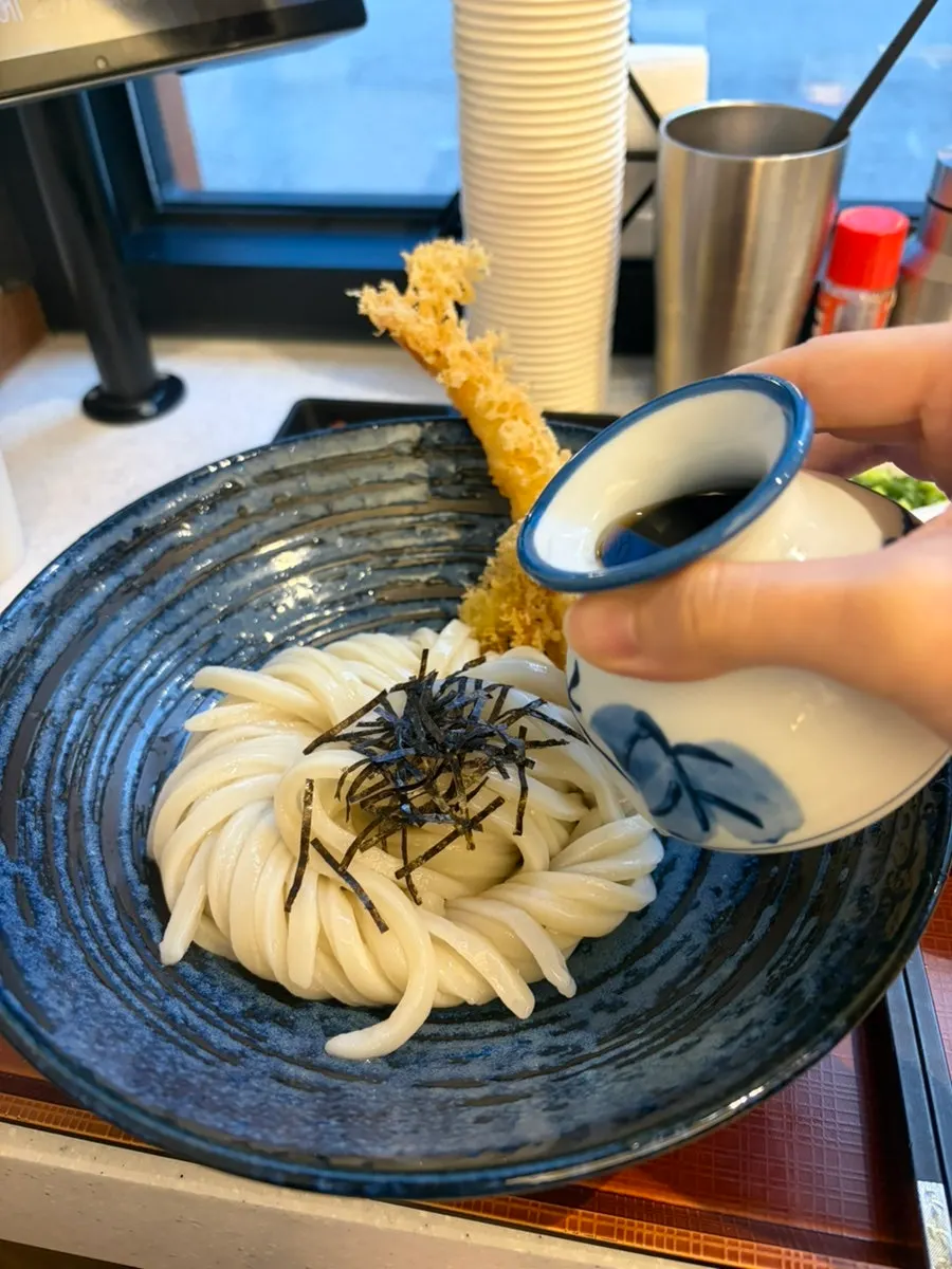 붓카케우동에 차가운 쯔유 소스를 붓는 모습