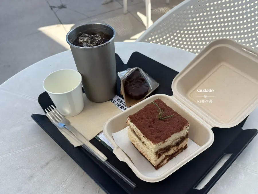 Decaf iced americano and tiramisu on a rooftop table
