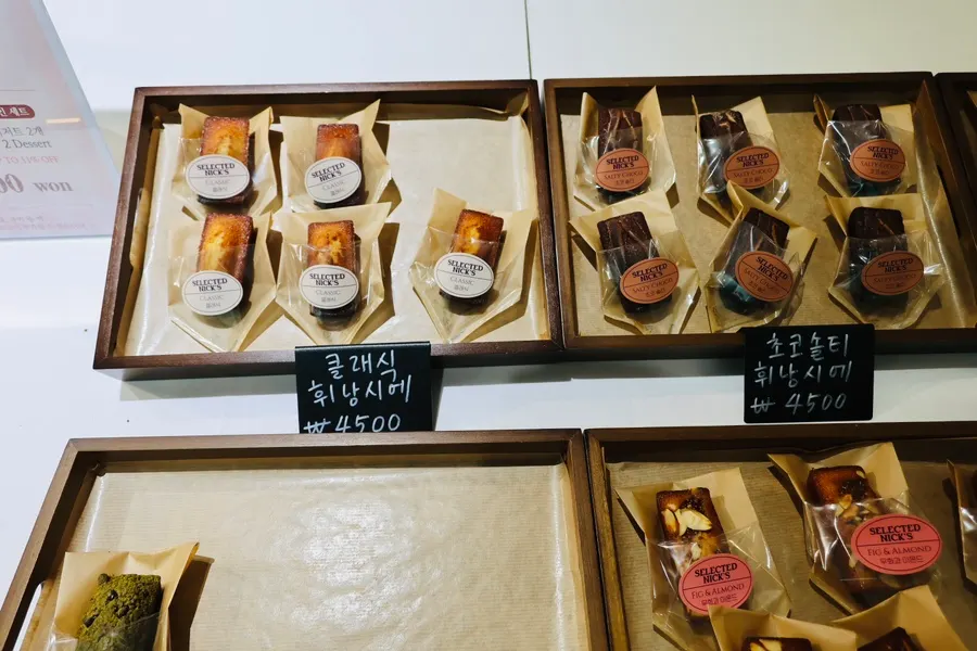 Display case with financiers, madeleines, and other baked goods