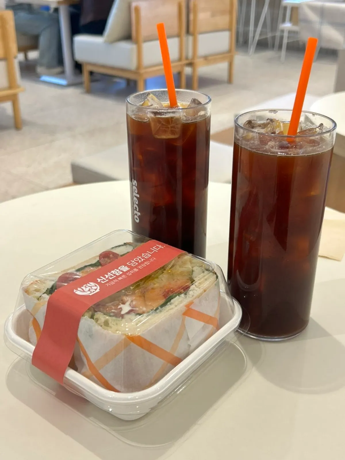 Two iced americanos and a packaged sandwich