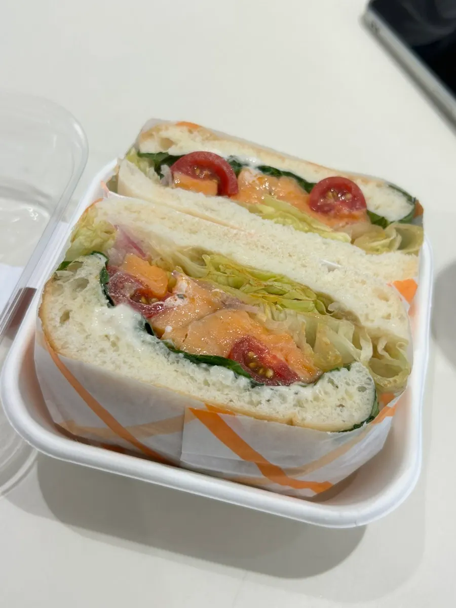 Salmon sandwich with visible lettuce and cherry tomatoes